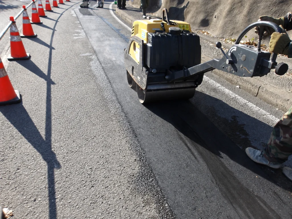 小榊線線路変更工事(管路工事):小型ローラーで仮舗装を転圧する作業