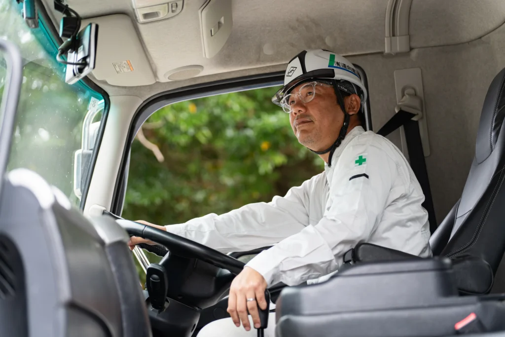 トラックの運転席に座る作業員