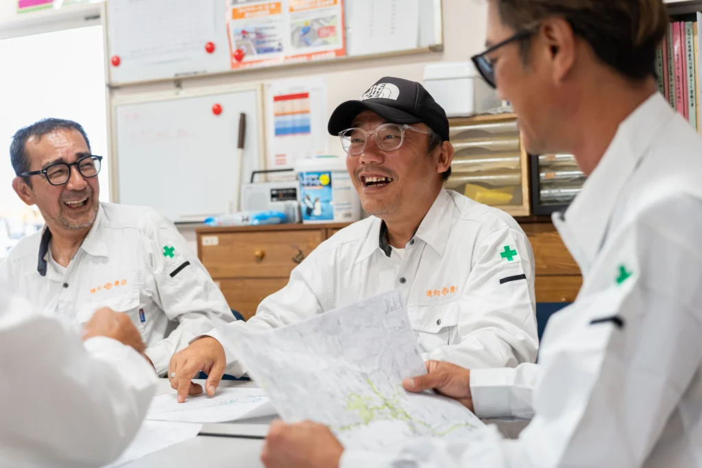 資料を囲んで笑顔を交わす社員