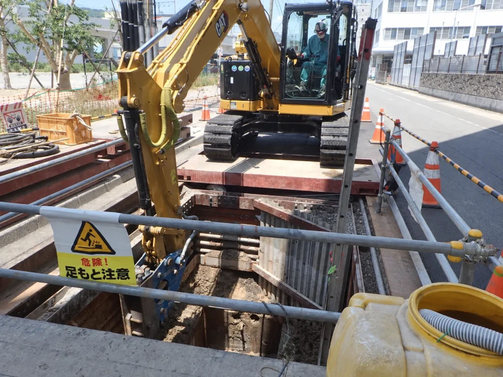 長崎駅周辺土地区画整理事業（2工区）電線共同溝工事：大型ブレーカーを用いて既設マンホールを破砕する作業